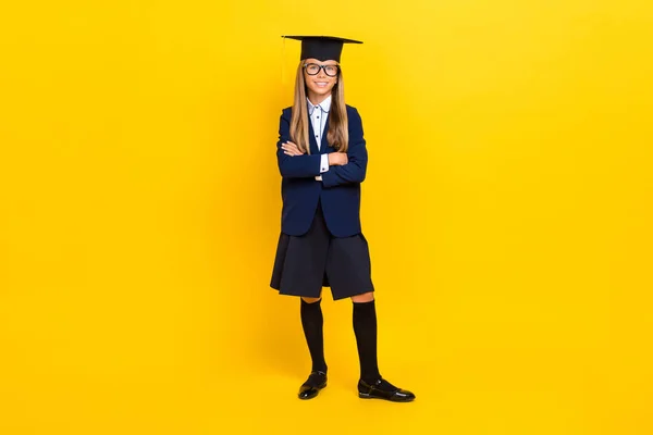照片上 一个聪明的 心情好的 积极的女学生 金发碧眼 身穿蓝色西装 双手交叉 呈黄色背景 — 图库照片