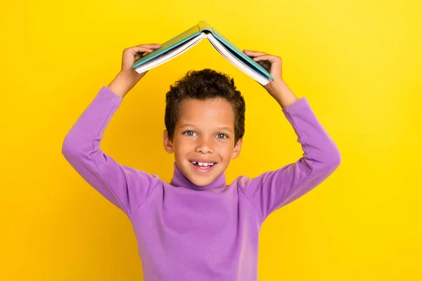 正面聪明学童微笑的照片扶住书架头顶上方的黄色背景 — 图库照片