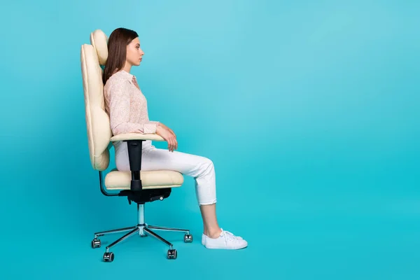 严肃而有趣的女商人坐在舒适的椅子上的侧写照片老板的位置看起来空荡荡的 新的空位被蓝色的背景隔开了 — 图库照片