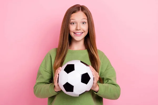 可爱快乐的女学生身穿绿色运动衫 手持足球 背景呈粉红色 — 图库照片