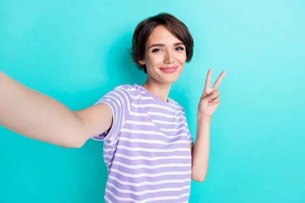 Portrait of nice pretty good mood girl with bob hairdo wear striped t-shirt showing v-sign doing selfie isolated on teal color background.
