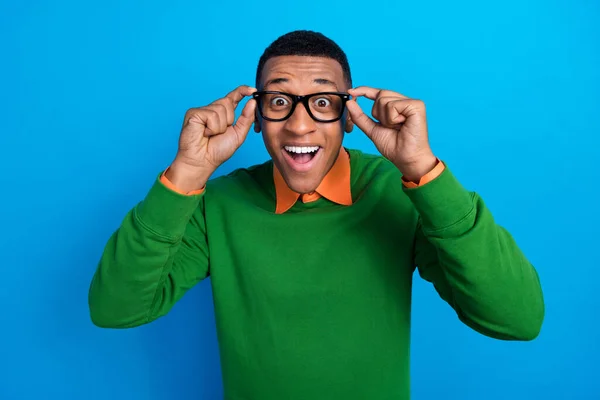 用绿色套头衫的手指触摸蓝色背景的眼镜 刻画了一个快乐喜庆的男人橙色衬衫的形象 — 图库照片