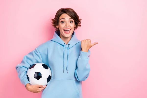 若いかなり魅力的なかわいい女性の写真は ピンクの色の背景に隔離された空のスペースを演出スポーツ衣装パーカーサッカーボール励起正指を着用 — ストック写真