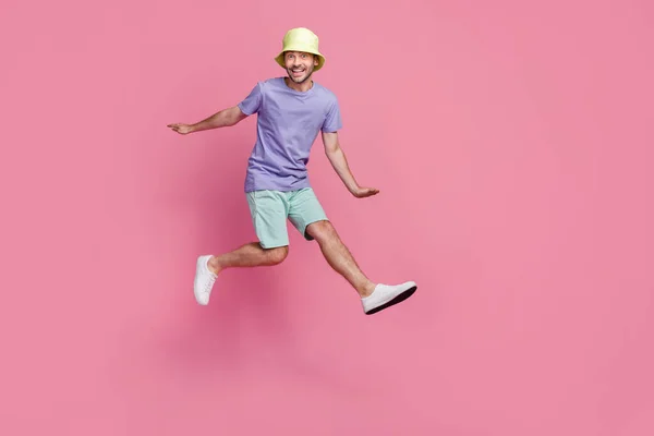魅力的な若い男のフル長さの写真興奮観光ビーチパーティージャンプドレストレンディーな青の服ピンク色の背景に孤立 — ストック写真