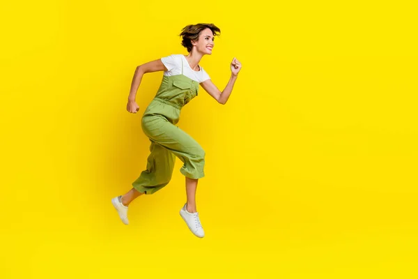 プロフィールボディサイズ写真の若い遊び心のある女の子高速ランナー空のスペースジャンプ空気締め切り用週末空のスペース隔離された黄色の色の背景 — ストック写真