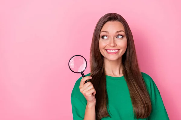 stock image Photo of gorgeous adorable pretty girl dressed green t-shirt look empty space hold magnifying glass isolated on pink color background.