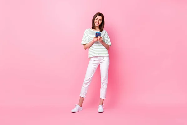 フル長いです写真の明るいです可愛いです女性服スタイリッシュなホールド電話タイプのボーイフレンド隔離されたピンク色の背景 — ストック写真