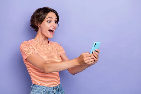 照片上兴奋的漂亮女士用手机上网与朋友们见面 看网络摄像头空旷的空间隔离在紫色的背景下 — 图库照片