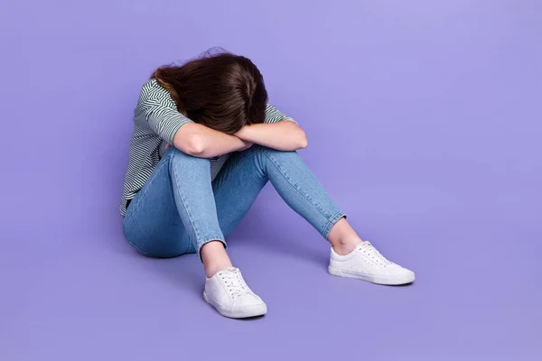 Photo of sad upset lady sitting floor hiding head face crying bad mood problem lost job empty space isolated on purple color background.