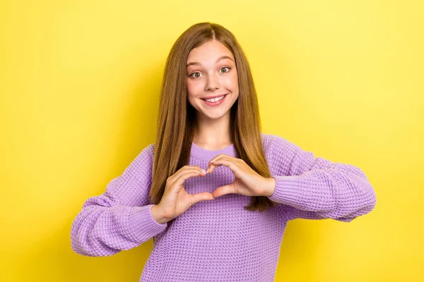 Photo of positive adorable girlfriend wear violet sweater two arm finger make heart shape charity event isolated on yellow color background.