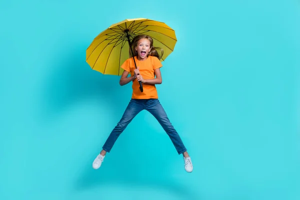 Full body length photo of young cute preteen girl wear casual outfit windy rainy forecast wrong hold parasol excited isolated on aquamarine color background.