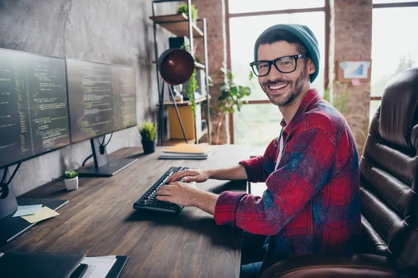 快乐积极的编码员戴着礼帽眼镜微笑着写下系统代码室内工作站阁楼的照片 — 图库照片