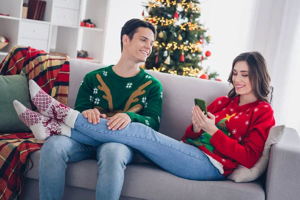 Photo portrait concept of two people wear ugly warm ugly sweaters chilling lying sofa atmosphere decor enjoy xmas time new apartment indoors.
