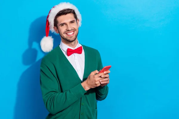 照片上穿着圣诞绿色羊毛衫 穿着时髦而快乐的家伙键入苹果三重唱设备空旷的空间孤立的蓝色背景 — 图库照片