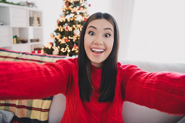 Photo of funny impressed girl wear xmas red pullover open mouth recording self video indoors home room.