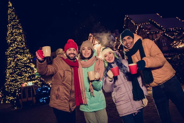 Portrait of group excited funny fellows hands hold hot chocolate tea mug christmastime magic spirit city center outdoors.