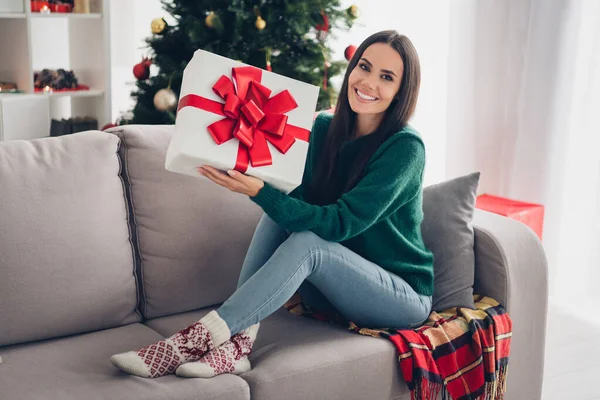 Photo of positive excited lady dressed knitted x-mas sitting couch rising present box indoors house room.