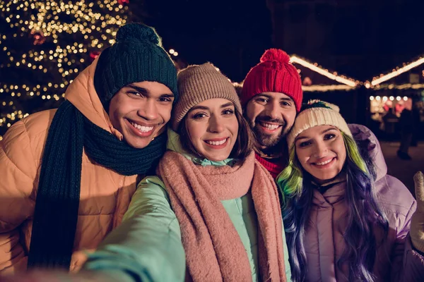 Photo of group excited positive people make selfie spend magic christmastime walk trade buy souvenirs outside.