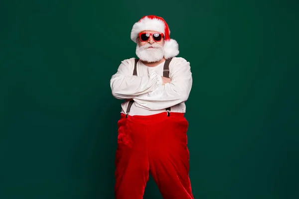 Portrait of stylish decisive content confident Santa wearing suit suspenders prepared ready for feast festive party promo sale promotion discount isolated over red background