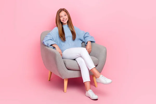 フルボディ長いです写真の若いです陽気な女子高生着用青ニットセーター座っている冷たいソファ家に隔離されたピンク色の背景 — ストック写真