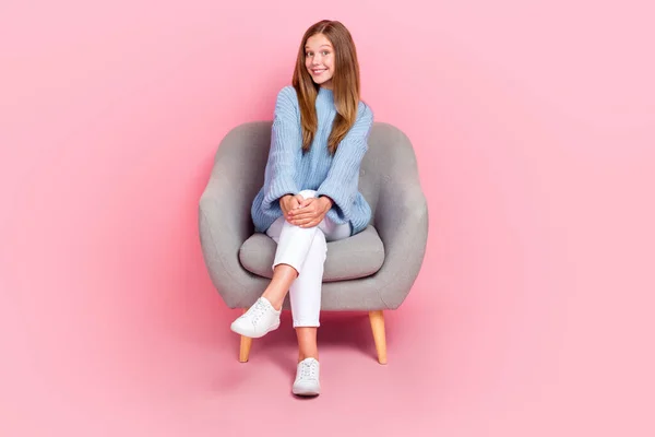 フル長さサイズ写真の若いかわいい学童ティーネージャーリラックスグレー快適な椅子着用ニットブループルオーバー隔離ピンク色の背景 — ストック写真