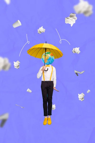 年轻绅士装束男人拿着黄色雨伞保护着头星球从蓝色背景隔离的纸屑中坠落下来的照片概念 — 图库照片