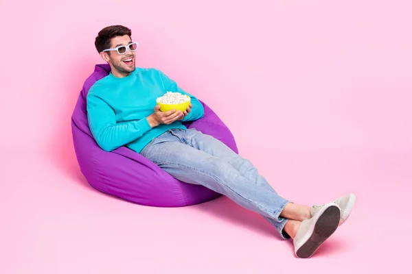 魅力的な若い男のフルボディ写真座っているビーンズバッグ3Dメガネを食べるポップコーンは ピンクの色の背景に隔離された流行の青い服を着用 — ストック写真