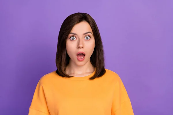 若い可愛い女性の閉鎖写真オレンジ色のトレーナーを着用口を開けて予期せぬ反応明るい紫色の背景に隔離された良いニュース情報 — ストック写真