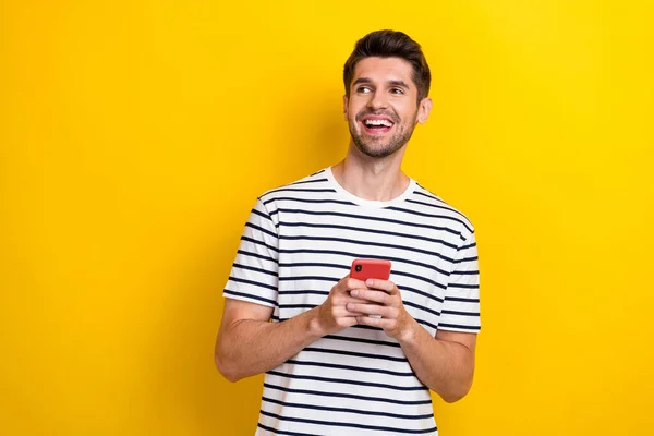 正の陽気な男の写真を保持電話おもちゃの笑顔は黄色の色の背景に隔離された空のスペースに見える — ストック写真