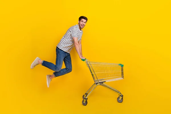 全长照片 色彩艳丽的男子身穿白色T恤衫 跳高购物超市食品孤立的黄色背景 — 图库照片
