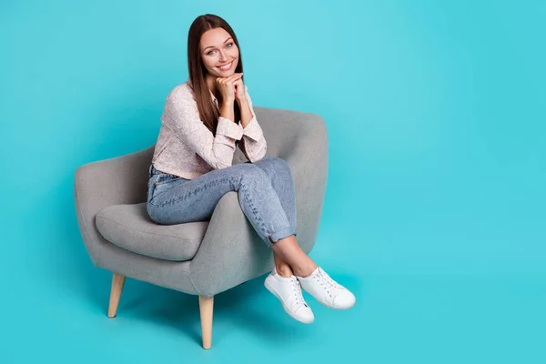 Photo of sweet lovely lady sit comfy chair arm under face dressed trendy outfit clothes empty space isolated on cyan color background.