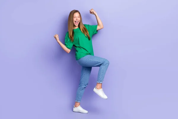 フル長いです写真のラッキー面白い女の子ドレスグリーンTシャツウォーキング上昇拳隔離された紫の色の背景 — ストック写真