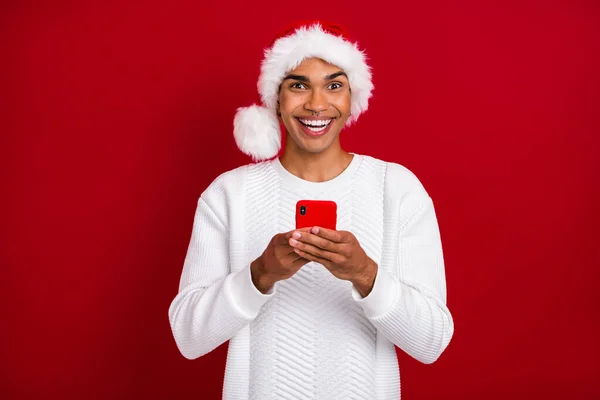 写真のハンサムな興奮男の歯の笑顔手ホールド使用電話隔離で赤の色の背景 — ストック写真