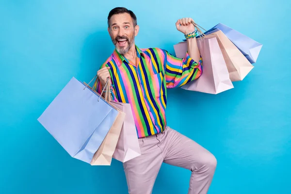 Photo of positive crazy man wear vintage trendy outfit rejoice buy new collection clothes mall center isolated on blue color background.