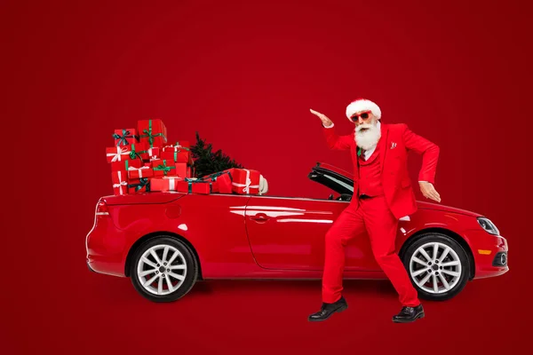 在灰色背景的隔天 圣诞老人在车前嬉戏 形体全貌迷人 滑稽可笑 — 图库照片