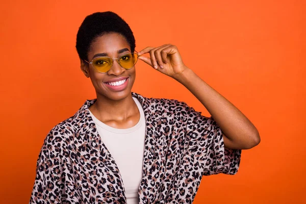鮮やかなオレンジ色の背景に独立したタッチ仕様のアイウェアを身に着けている魅力的な陽気な流行の女の子の肖像画 — ストック写真