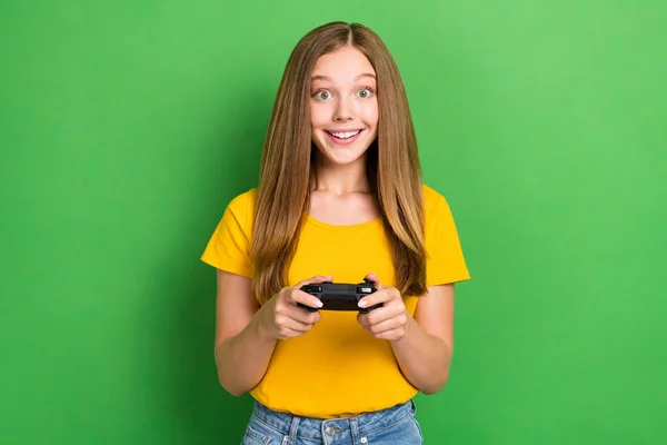 兴奋的女学生穿着橙色T恤 拿着游戏垫的照片 放松与绿色背景隔离的情绪 — 图库照片