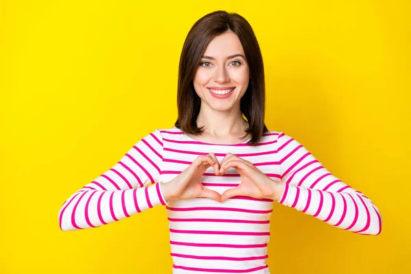 美しい若い女性の笑顔の腕の写真の肖像画心臓心臓の心臓病のシンボルは 黄色の色の背景に隔離された流行の縞模様の外観を着用 — ストック写真