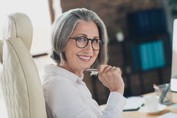 快乐积极的女性专家戴眼镜在室内工作间写便条的照片 — 图库照片