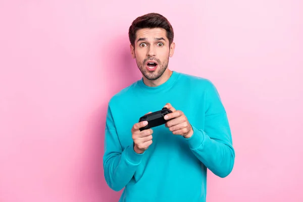 魅力的な若い男の遊び場の写真のポートレート印象的な損失のビデオゲームピンクの色の背景に隔離されたトレンディーな青の服を着る — ストック写真