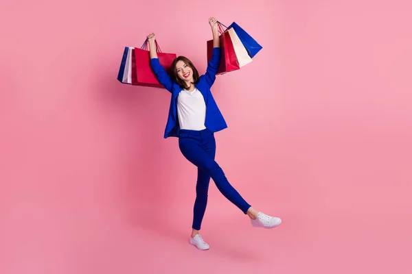 明るい成功した女性の写真は青スタイリッシュな服の手をホールドバッグ満足クールなショッピングピンク色の背景に隔離された — ストック写真