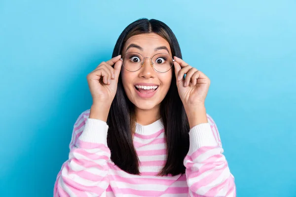 Photo of funny excited lady wear striped sweater arms spectacles open mouth isolated blue color background.