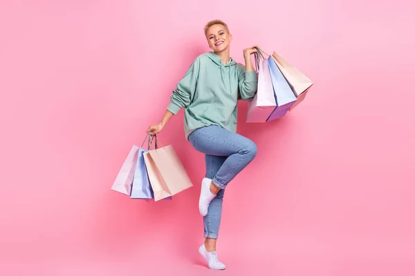 正の幸せな女性の顧客の完全な長さの写真はファッショナブルな服を身に着けているピンク色の背景に隔離された低価格を喜ぶ — ストック写真