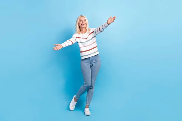 Full length photo of cheerful optimistic lady wear stylish clothes open arms glad see you isolated on blue color background.