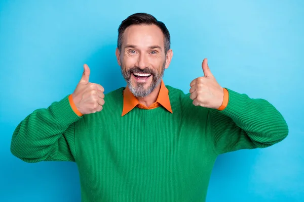 Photo of cheerful funny person two hands fingers demonstrate thumb up toothy smile isolated on blue color background.