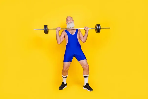 Full body size photo of funky comic grandfather trying hard dumbbell up exercise no more power grimace isolated on yellow color background.