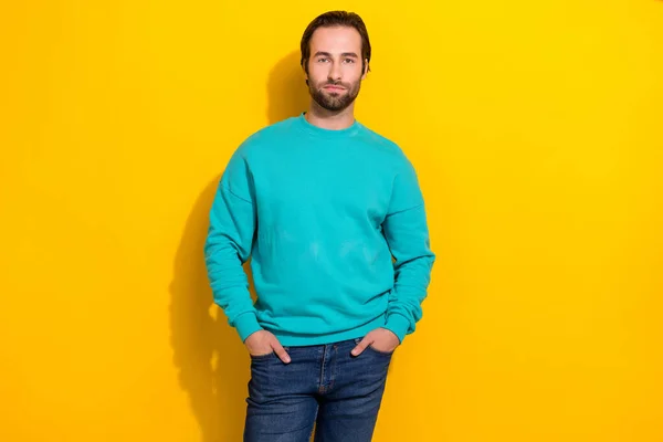 Photo of young successful career office worker brunet hair man wear bright blue pullover put arms pockets cadre isolated on yellow color background.