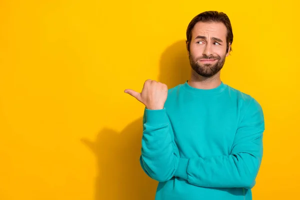 Photo of funny look empty space suspicious grimace student guy wear blue pullover distrust media tv news politics isolated on yellow color background.