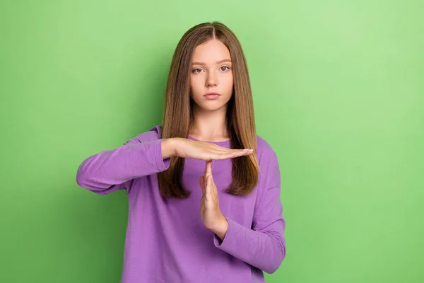Photo of serious lady wear trendy purple spring clothes demonstrate gesture stop time symbol isolated on green color background.