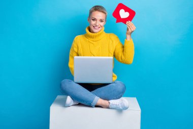 Photo of adorable pretty lady blogger sitting podium raise red card share instagram facebook post repost isolated on blue color background. clipart